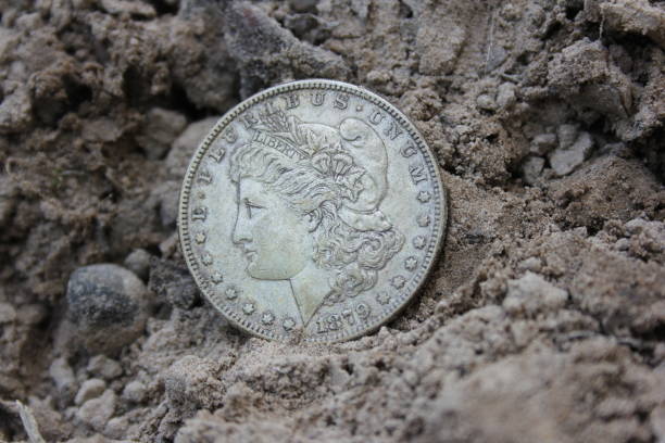 istock 1879 Morgan Silver Dollar On Ground in Dirt Front View 2149357032