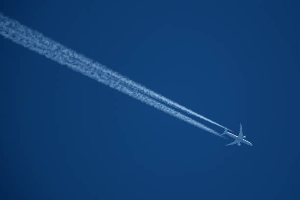istock Airplane in the blue sky with contrails in the air. 2149358418
