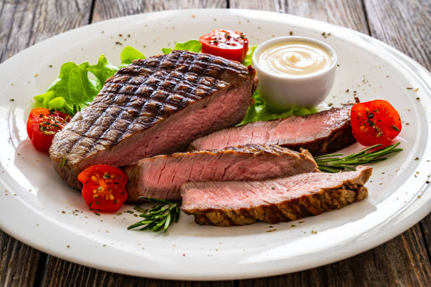 istock Grilled beef sirloin steak with fresh vegetables on wooden table 2149358483