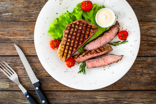 istock Grilled beef sirloin steak with fresh vegetables on wooden table 2149358505