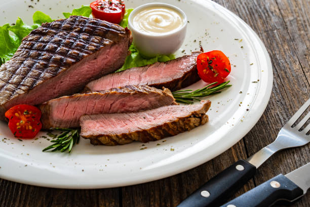 istock Grilled beef sirloin steak with fresh vegetables on wooden table 2149358528