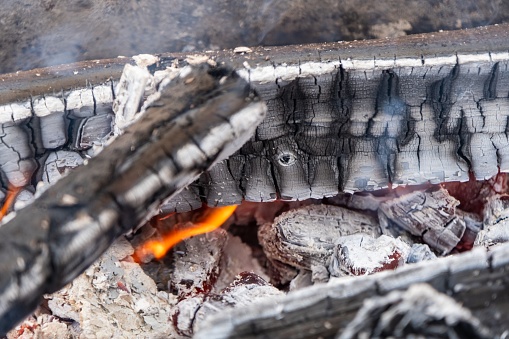 A close-up view of wood slowly burning into ash and embers.