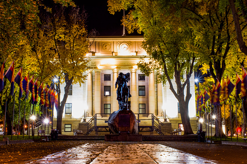 A cowboy statue and Arizona State Flags Guard the entrance to the Yavapai County Courthouse.