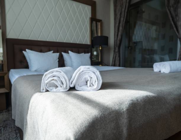 Comfortable hotel room with bed, pillows, and towels on the bedding