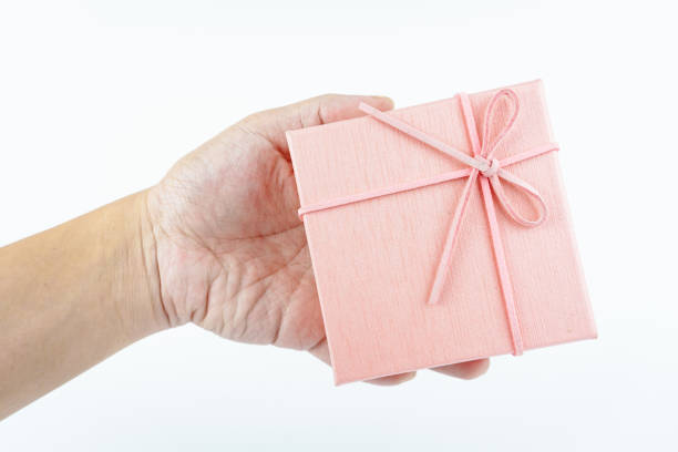 istock Hand holding pink gift box on white background. 2149359825