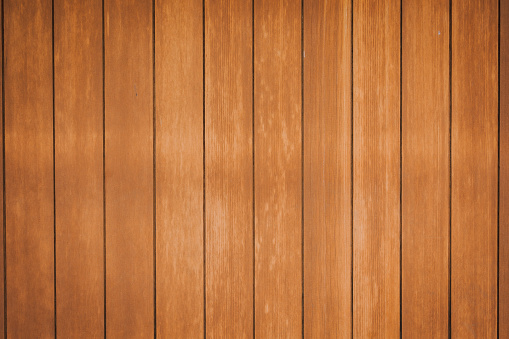 A wooden wall with vertical planks painted in brown color