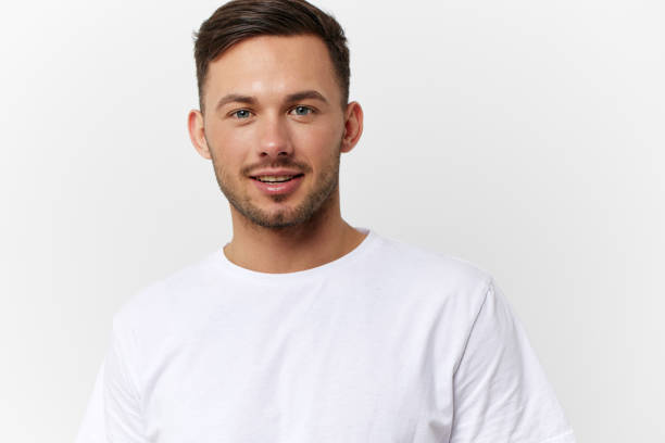 istock Cheerful cute happy young tanned handsome man in basic t-shirt smile at camera posing isolated on over white studio background. Copy space Banner Mockup. People emotions Lifestyle concept. Portrait 2149361748