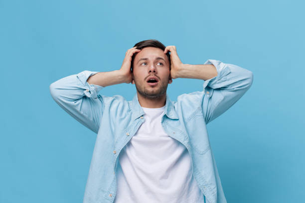 istock Unhappy concerned make difficult decision tanned handsome man in casual basic t-shirt touch head posing isolated on blue studio background. Copy space Banner Mockup. People emotions Lifestyle concept 2149362049