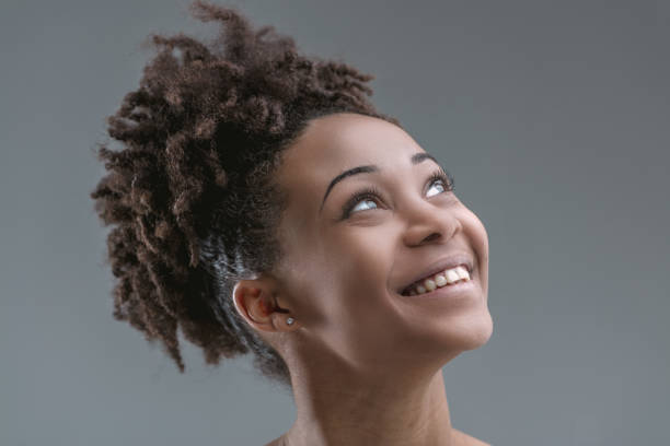 istock Afro-haired woman, exuberant, anticipates with smile 2149366519