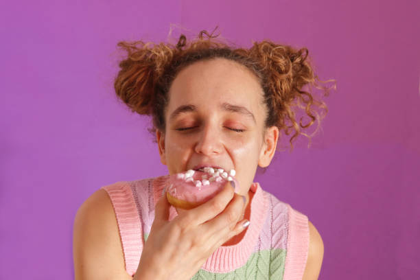 istock Pretty young caucasian woman eating a donuts 2149366825