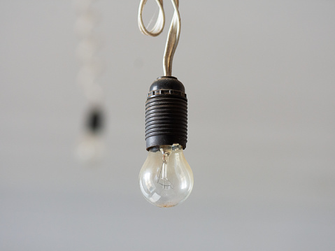 An old incandescent lamp hangs on an electric cable.