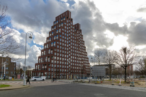 Amsterdam, the Netherlands. 23 March 2024. De Piramides. Two pyramid shaped apartment buildings in Amsterdam West designed by architect Sjoerd Soeters. imposing clouds.