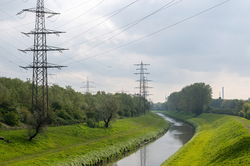 electric pylons with canal in the landscape