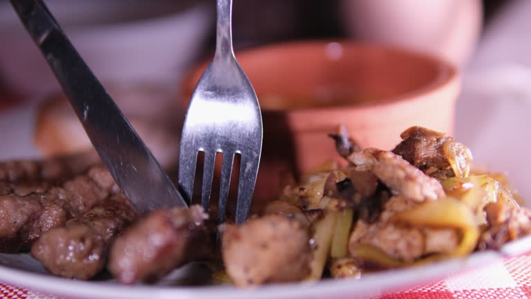 Fork knife kebab cutting roasted meat kebab on wooden desk, grilled meat kebab, closeup