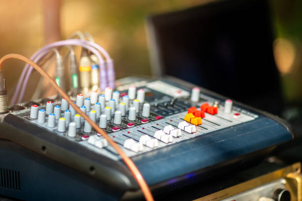 Close-up of laptop on a wooden shelf with playing music against dark concrete wall with copy space.