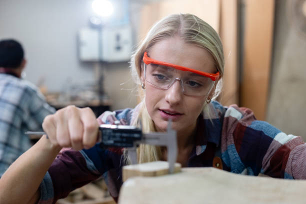 istock Worker carpenter or craftsman using vernier calipers measuring dimensions of woodwork. Female working wood design at workplace. wooden small business factory. 2149374848