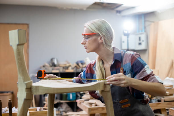 istock young carpenter women using measuring tape looking wood size at workspace. craftsman profession in wood factory. 2149374902