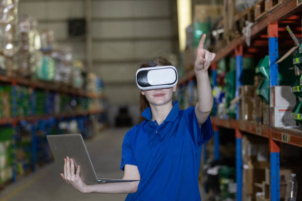 istock woman warehouse worker using virtual reality glasses. goggles innovation future watching education internet. Work is controlled through a modern digital system. 2149376938