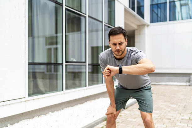 istock Young Caucasian man using his watch to track pulse while jogging in the city 2149377850