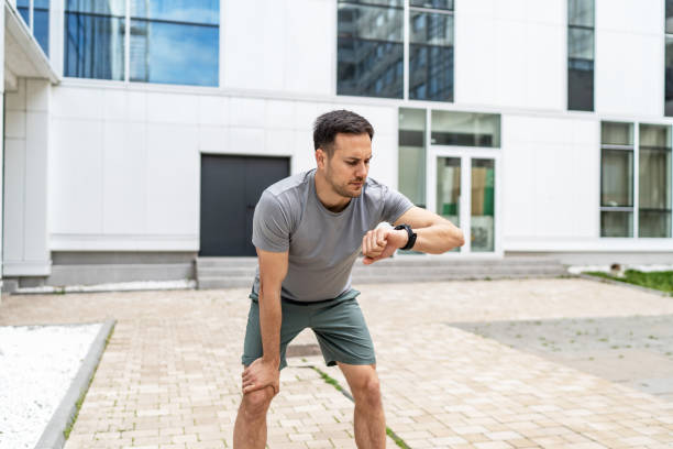 istock Young Caucasian man using his watch to track pulse while jogging in the city 2149377900