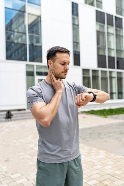 istock Young Caucasian man using his watch to track pulse while jogging in the city 2149377958