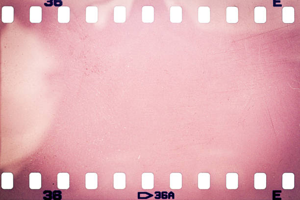 Dusty and grungy 35mm film texture or surface. Perforated scratched camera film isolated on white background.