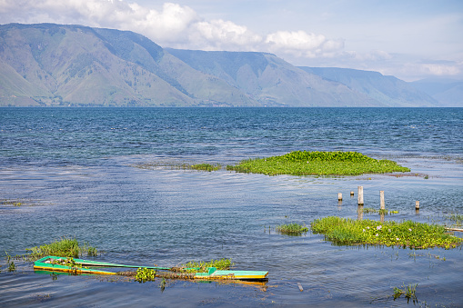 Half sunk canoe, which has been utilized as a fishing vessel, in the volcanic Lake Toba in the northern part of Sumatra