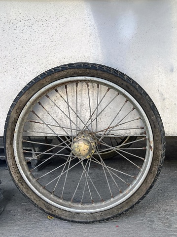 a photography of a bicycle wheel with a tire on the ground.