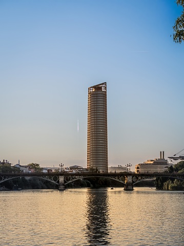 View of Seville Tower (Torre Sevilla) of Seville, Andalusia, Spain over river Guadalquivir at sunset, during summer