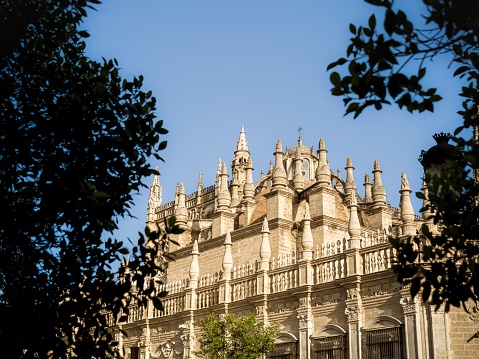 Low angle view of the coupola and the gothic facade ornaments of the cathedral of Seville, Andalusia, Spain