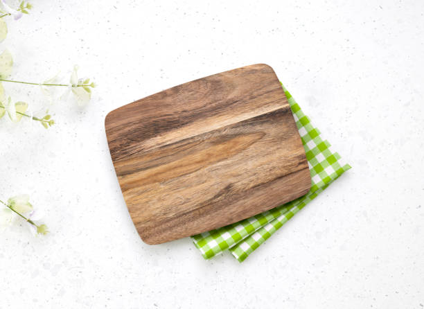 istock Kitchen wooden cutting board top view decorated with red picnic checkered cloth, serving dish empty space design, tableware on white. Food advertisement 2149389060
