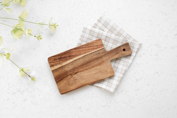 Cutting board top view, kitchen wooden tray decorated with checkered folded cloth on white table.Food backdrop.