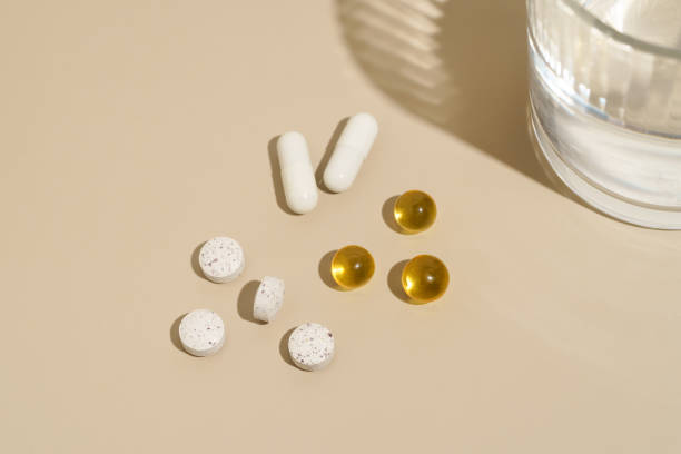 istock White and yellow capsule pills on beige isolated background. Background for your design. Concept of pharmacy, health, treatment and improvement. Image for your design 2149389671