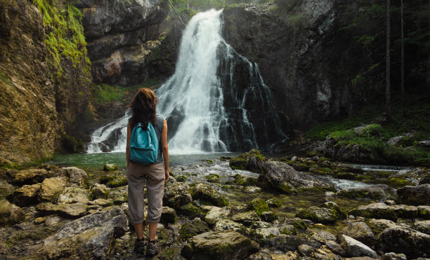 istock Female traveler at the waterfall in Austria 2149391714