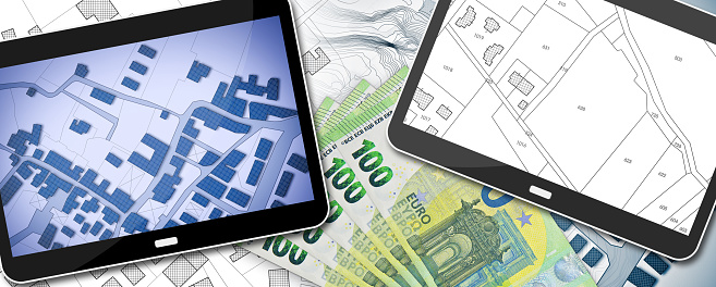 Property tax and costs on buildings - concept with an imaginary cadastral map on digital tablet and european euro banknote