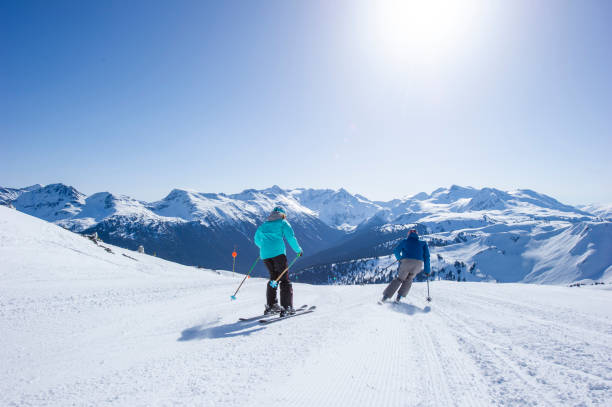 istock Friends ski down slope at ski resort 2149394196