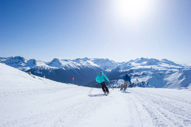 istock Friends ski down slope at ski resort 2149394199