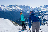 Friends ski down slope at ski resort