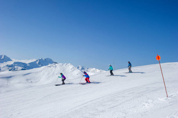 istock Friends ski down slope at ski resort 2149394261