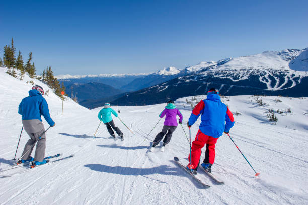 Friends ski down slope at ski resort