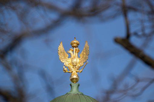 Golden double-headed eagle against a blue sky.
