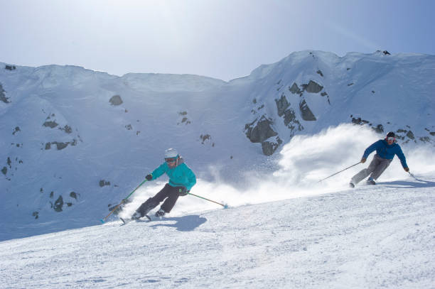 istock Friends ski down slope at ski resort 2149394391