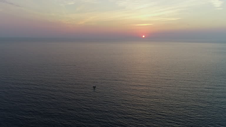 Aerial View of an Vintage Boat Sailing on the Blue Sea Towards the Setting Sun. Concept of Freedom, Timelessness, Vastness, Exploration, Solitude, Adventure, Serenity, Medieval Boat, Travel