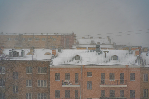 Snow blankets the rooftops of Saint Petersburg, capturing a somber winter cityscape amidst a heavy snowfall