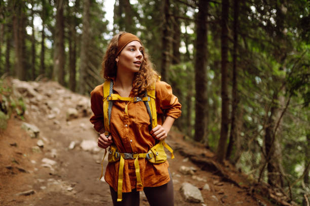 istock Hiking woman walk with a hiking backpack in spring green forest. 2149405220