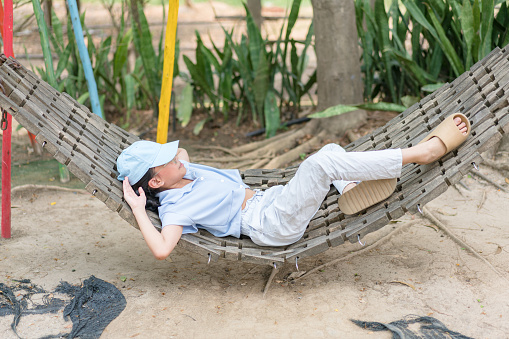 Girl lying on a natural wooden hammock