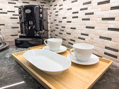 Coffee cups and coffee maker on a domestic kitchen