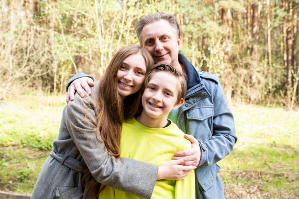 istock smiling father with daughter and son in the park 2149412079