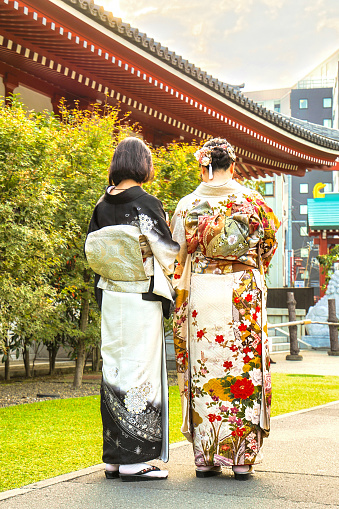 Tokyo, Japan - October 13, 2023:  The unidentifiable rear back view of two women tourists wearing kimono dress robes in Tokyo, Japan.