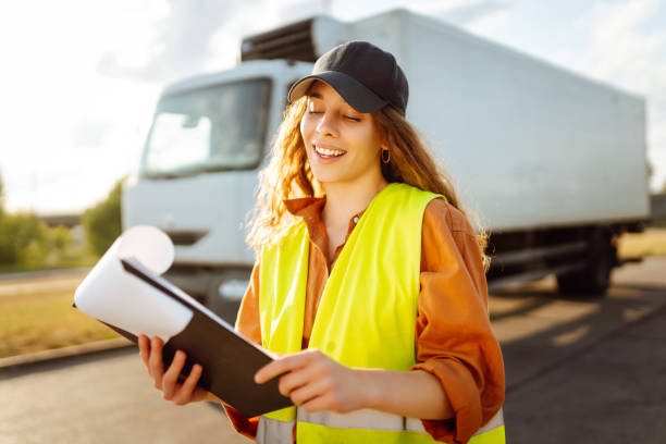 istock Young woman professional driver checking shipment list on a -parking lot. 2149413501
